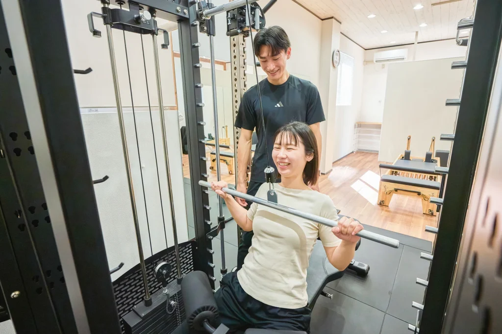 マシントレーニングで女性を指導する男性トレーナー
