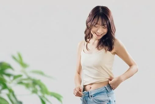 お腹の脂肪をつまんで気にする女性